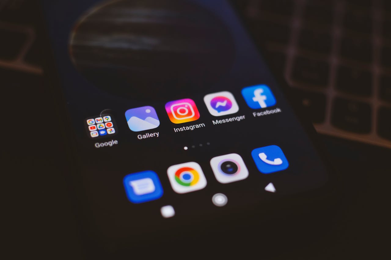 services-02 A smartphone displaying popular social media apps in a dimly lit environment, perfect for tech and communication themes.